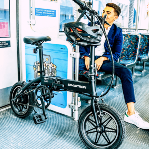 Young professional riding the train with his foldable electric bike, making this electric bicycle ideal for small spaces and city commuters