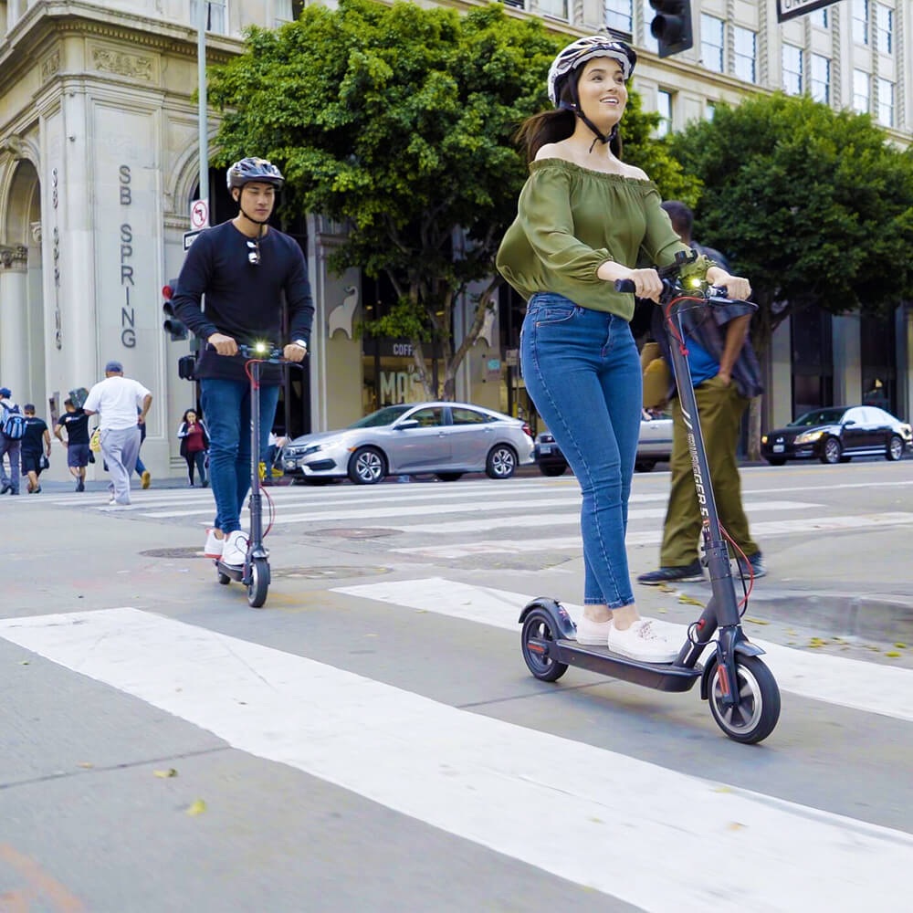 Couple riding their electric scooters around the city