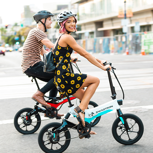Couple riding their electric foldable e-bike in the city