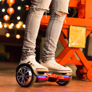 Person riding a red and black hoverboard, model Vibe T580 from Swagtron with Bluetooth