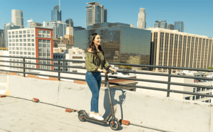 Girl riding her electric commuter scooter in the city