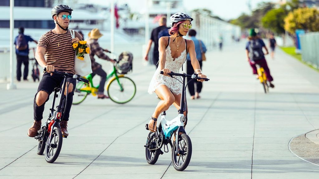 Couple wearing helmets, riding their EB7 electric bike from SWAGTRON.